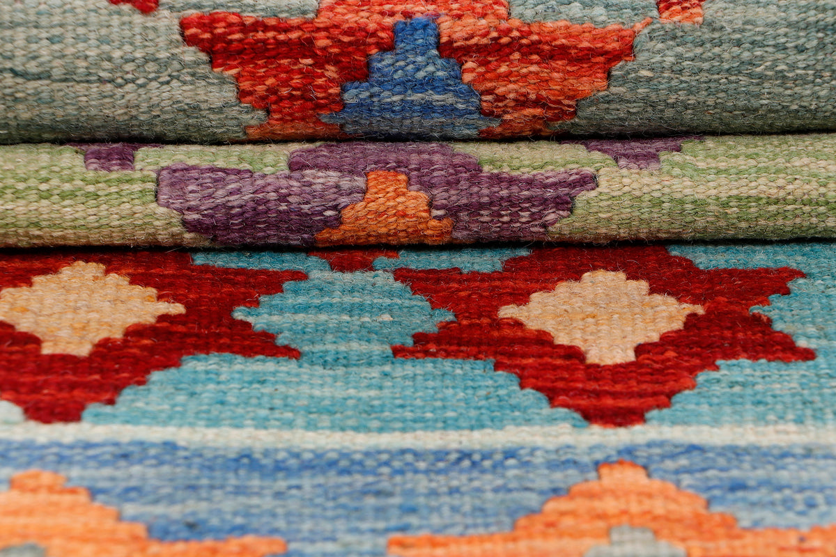 Multicolor kilim rug fabric close-up with blue, orange, and red geometric motifs