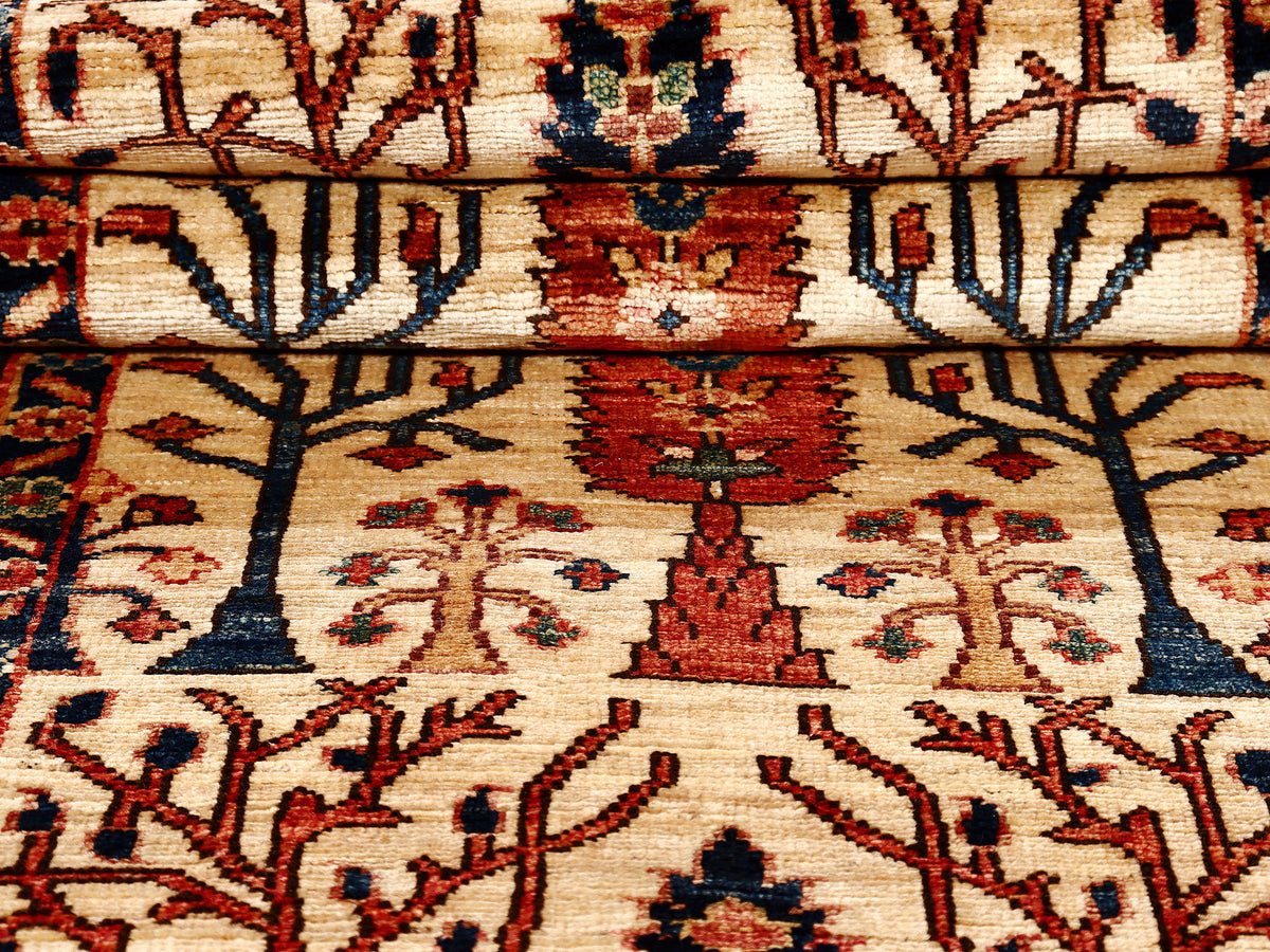 Close-up of cream rug field with red accents, blue tree motifs, and floral pattern