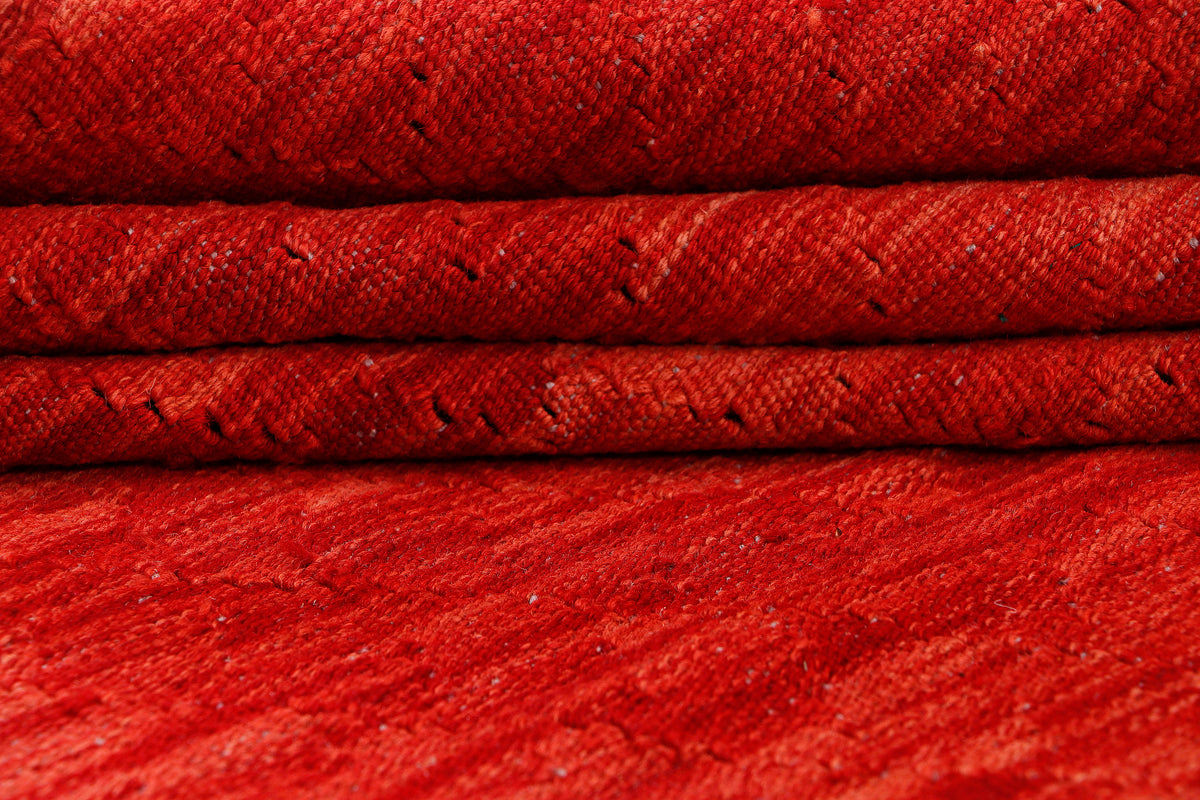 Red kilim rug folded detail showing textured flatwoven surface