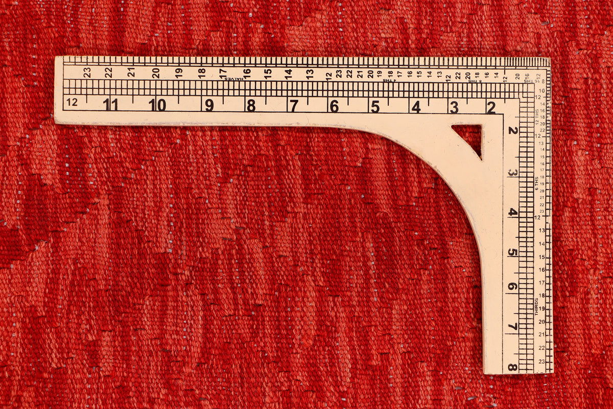 Red kilim rug measuring corner with ruler on the flatwoven surface