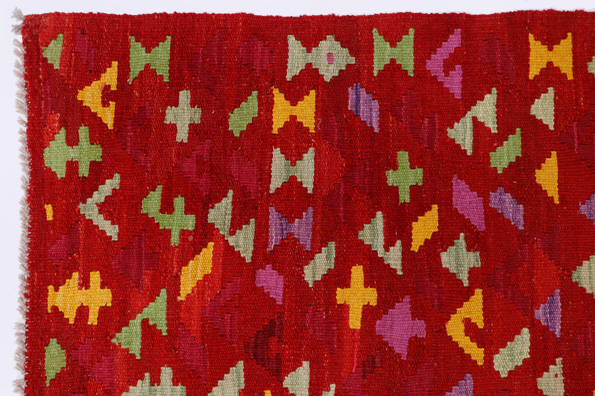 Crimson mosaic red kilim rug with multicolor geometric pattern close-up