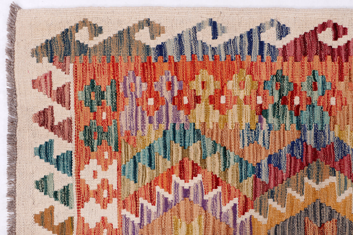 Kilim rug close-up with multicolor geometric motifs on beige base