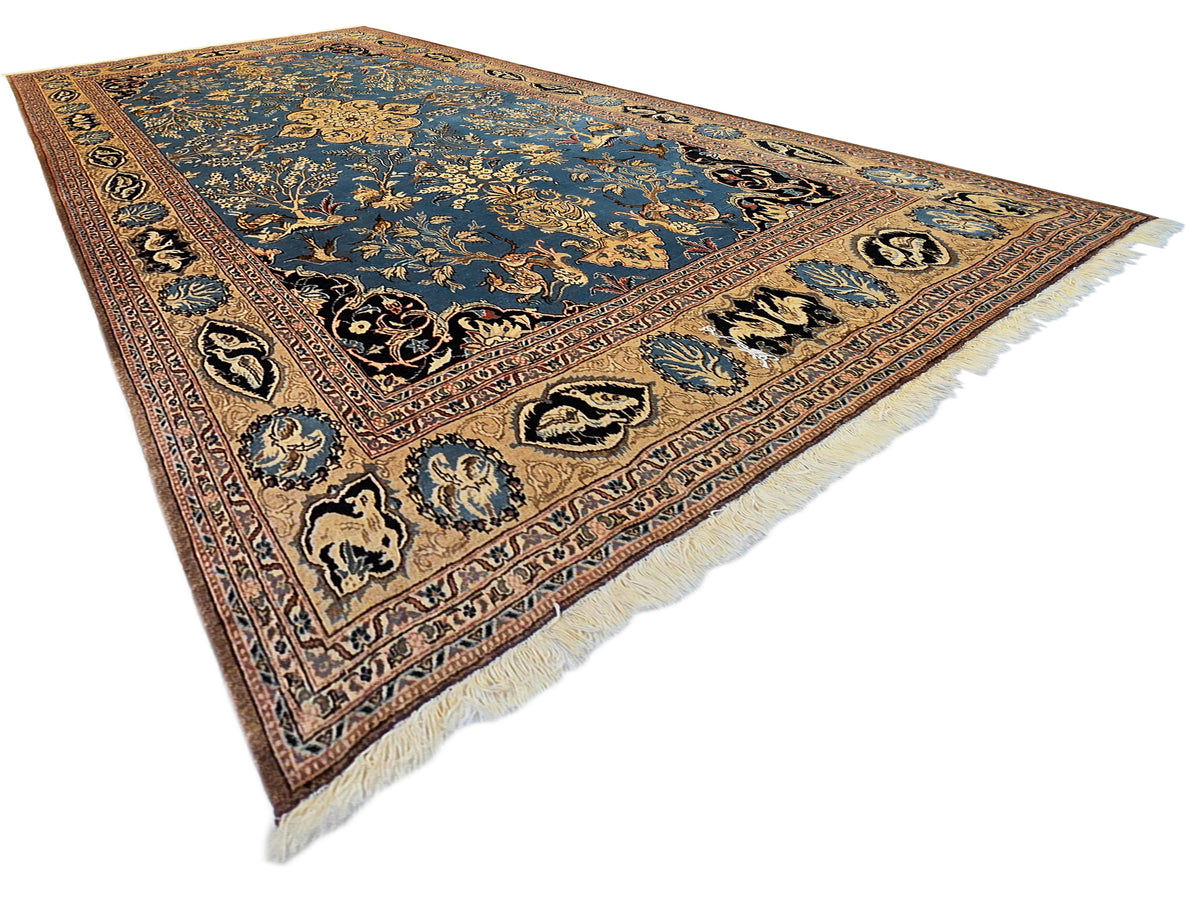 Ornate blue rug with central motif and cream fringe at corners