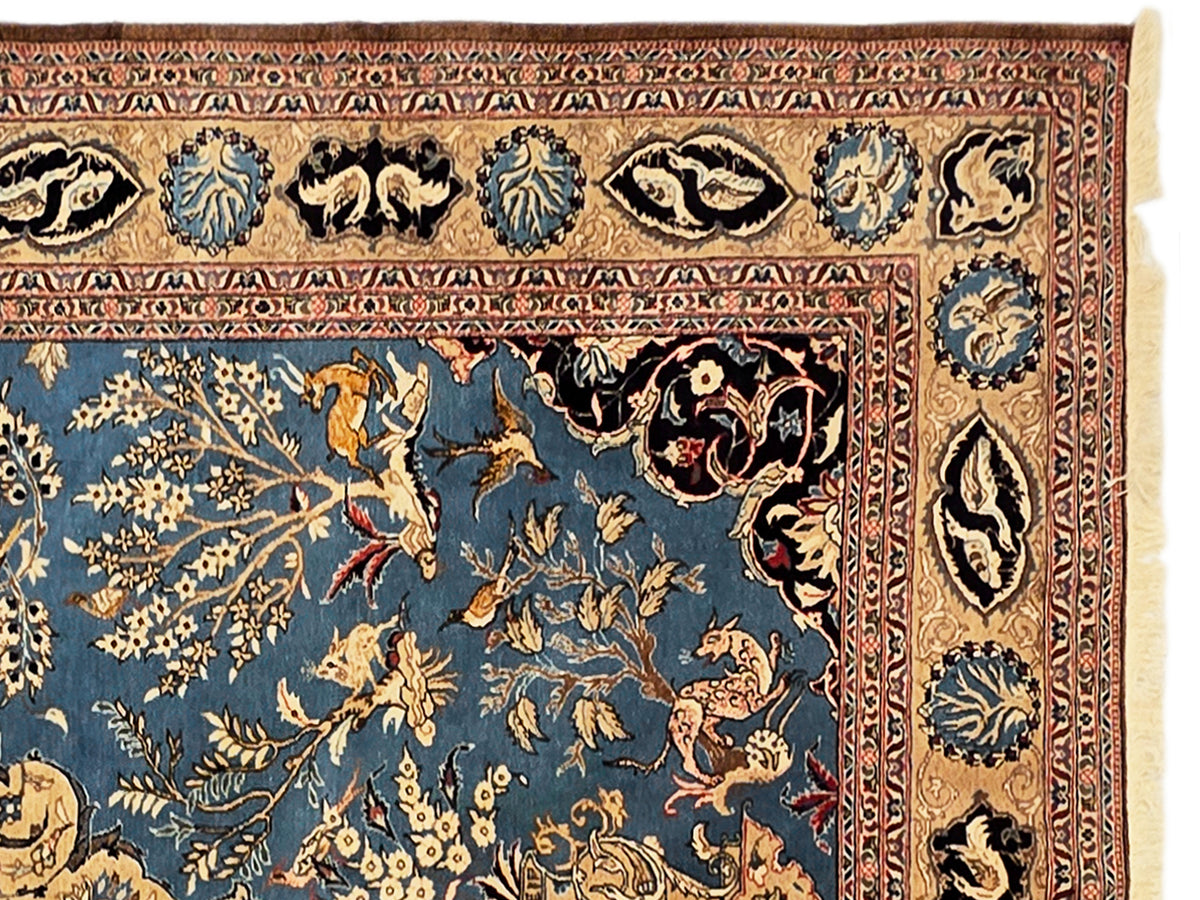 Close-up of blue rug border with floral motifs and cream fringe detail