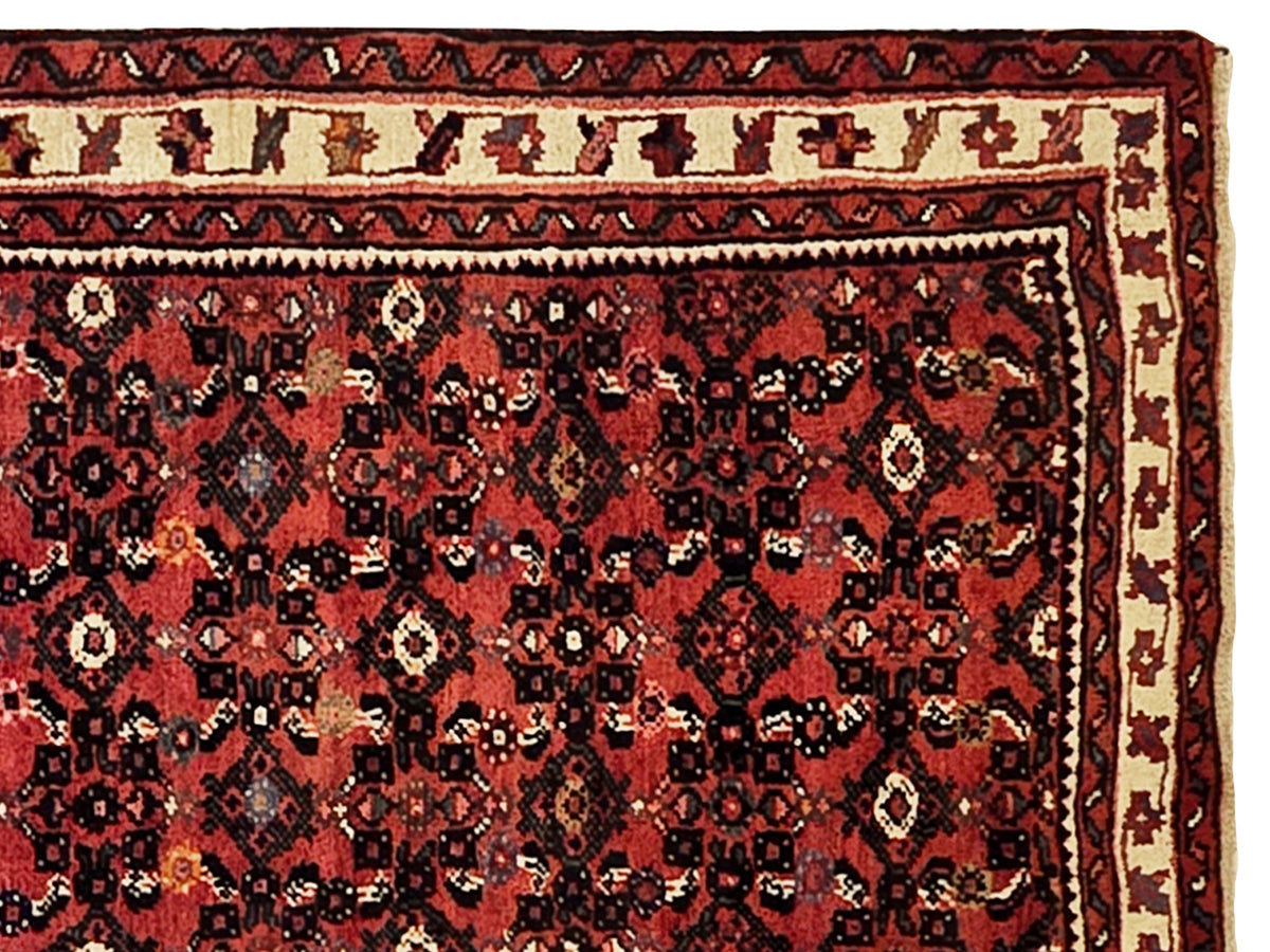 Close-up burgundy runner rug with dense navy and cream floral medallion pattern