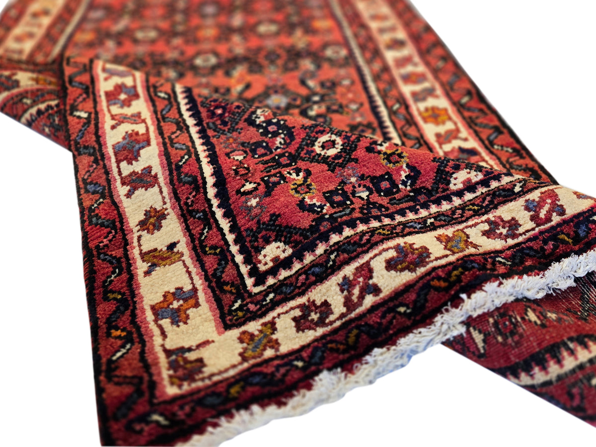 Burgundy runner rug with navy center motif, cream bands, and short fringed edge