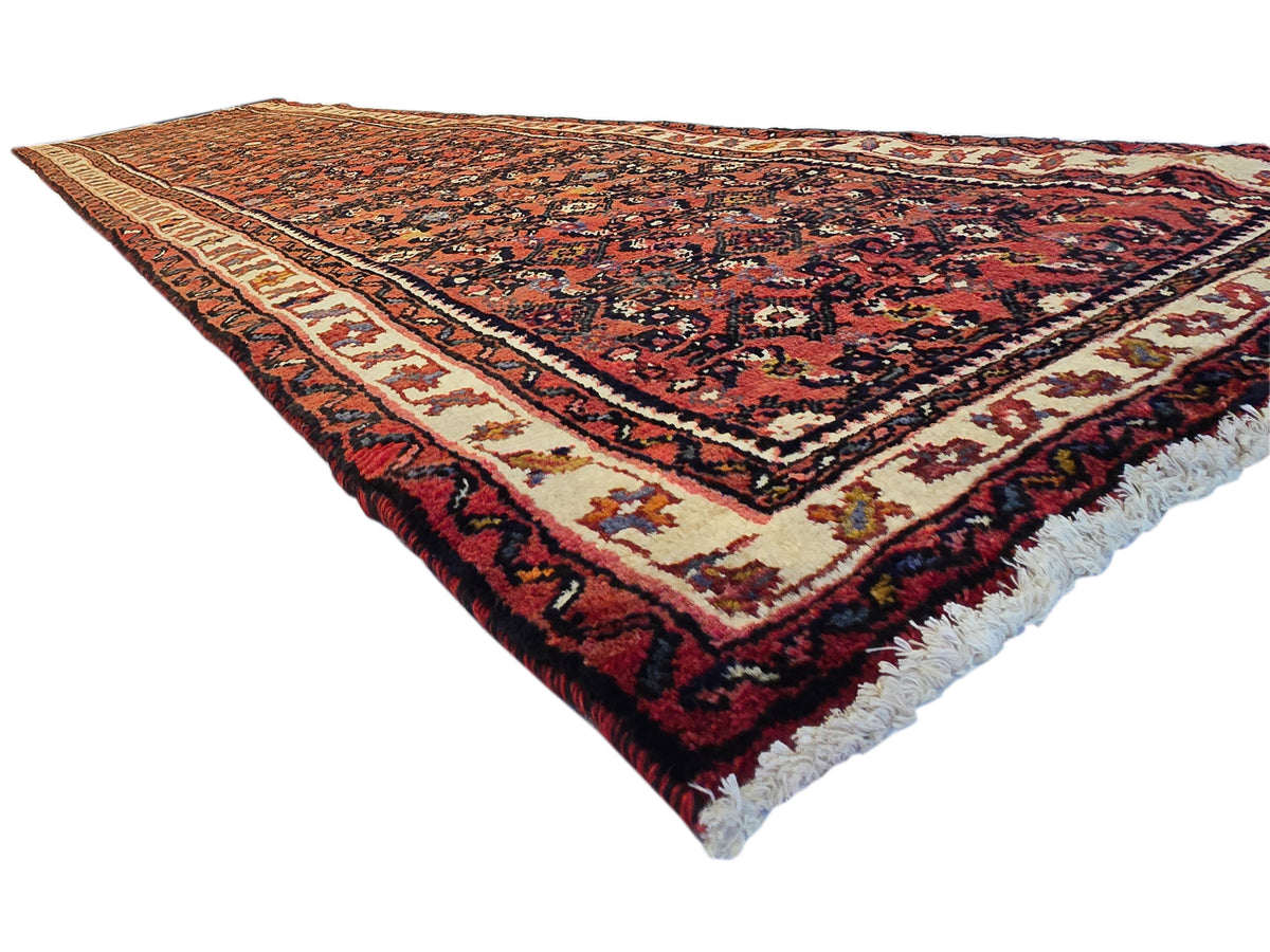 Burgundy runner rug with navy lattice medallions and cream border, fringed ends