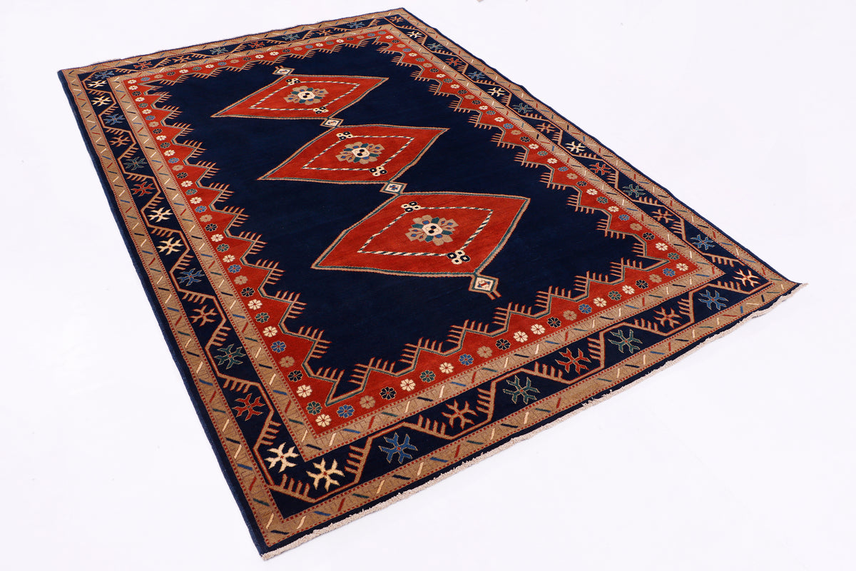Flat-lay geometric area rug in navy, red, and beige with central medallions, 289x203 cm.