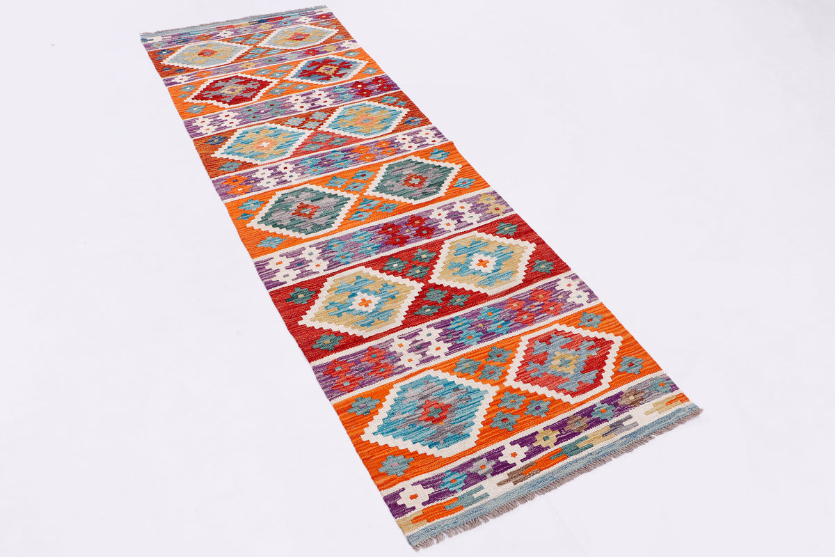 Kilim runner rug laid flat showing repeating orange, blue, and purple medallion motifs