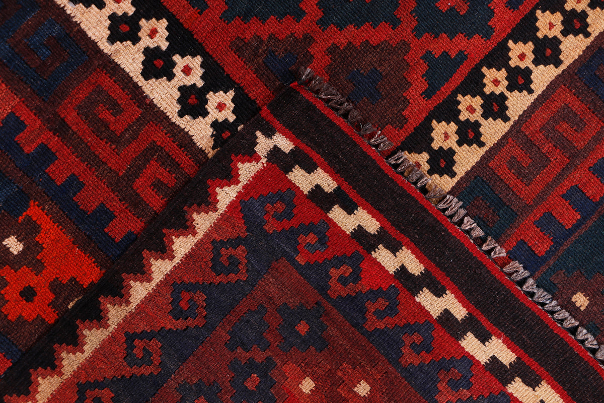 Kilim rug detail with crimson red, navy, and cream geometric stripes and motifs