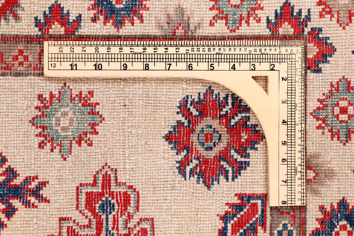 Kazak red rug with beige ground and blue-red medallion motifs, bordered edges