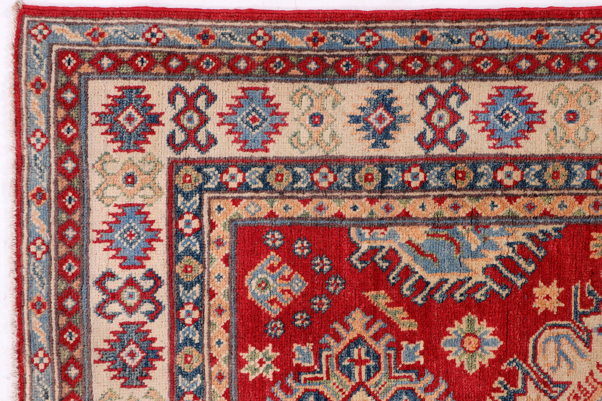 Red, blue, and cream rug border with repeating geometric medallions