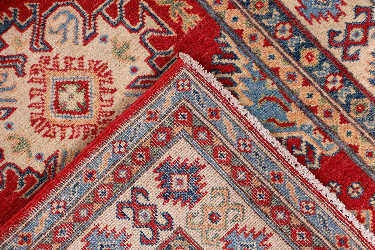 Cream and red rug with central medallion and multicolor geometric details