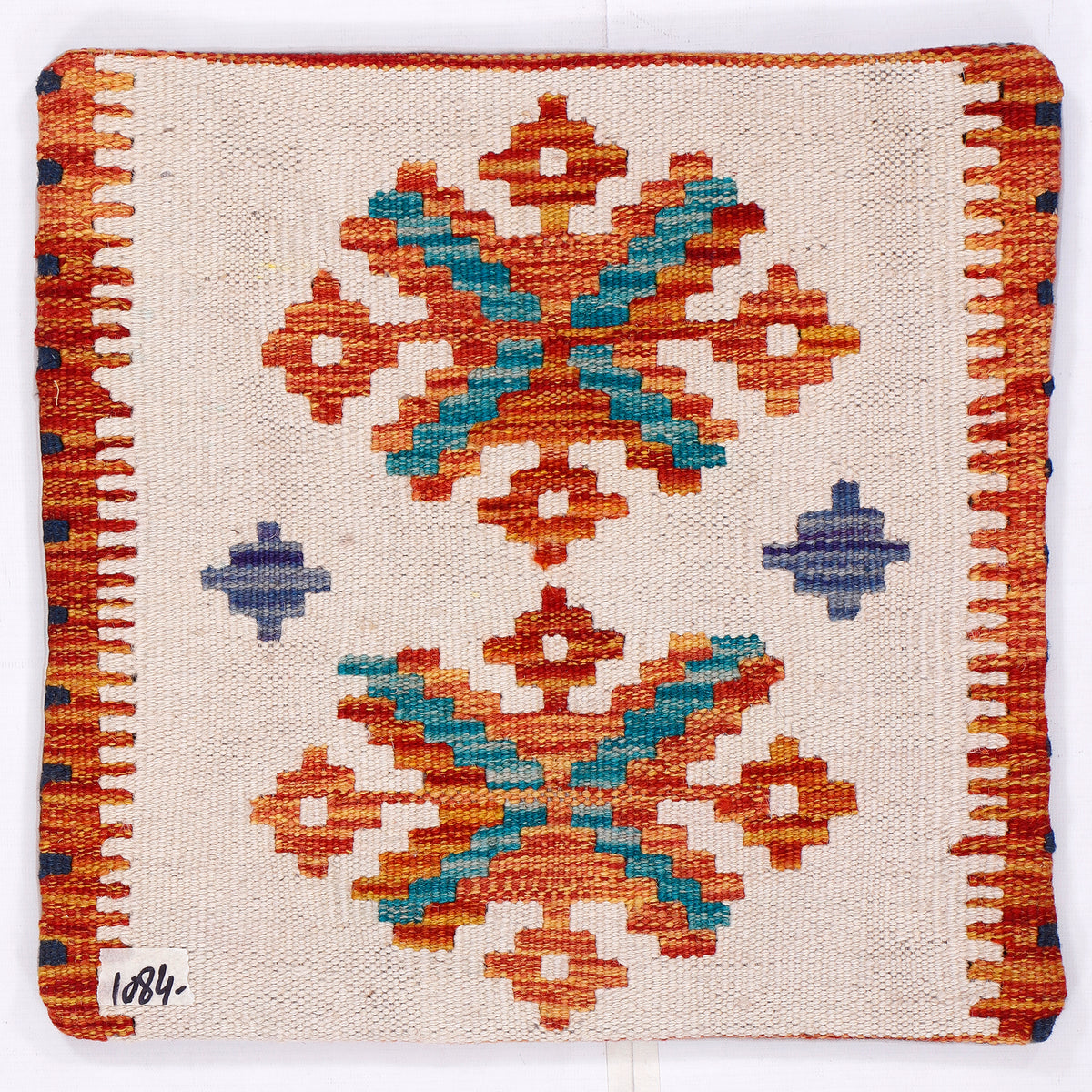 Cream kilim cushion cover featuring multicolor geometric star motifs and orange stitched edge.