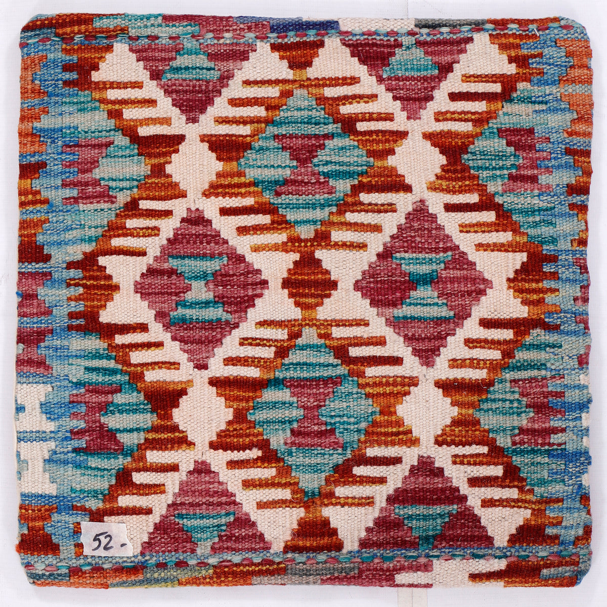 Diamond kilim cushion cover close-up, turquoise and red geometric lattice pattern