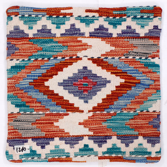 Kilim cushion cover close-up with blue, orange, teal geometric motifs on cream background