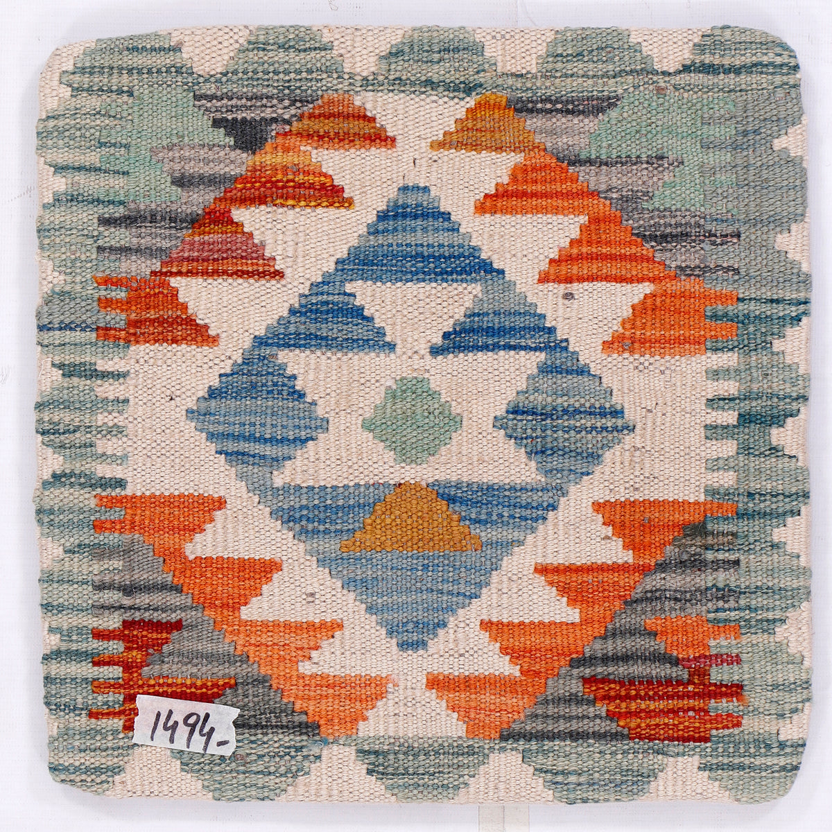 Kilim cushion cover close-up with geometric diamond motif in blue and orange