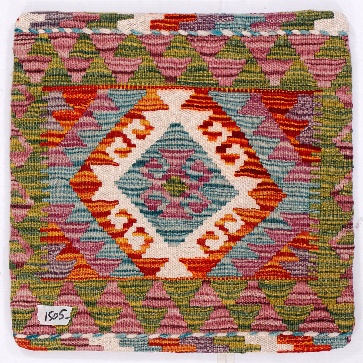 Kilim cushion cover close-up: central diamond medallion in blue, orange, green, and pink