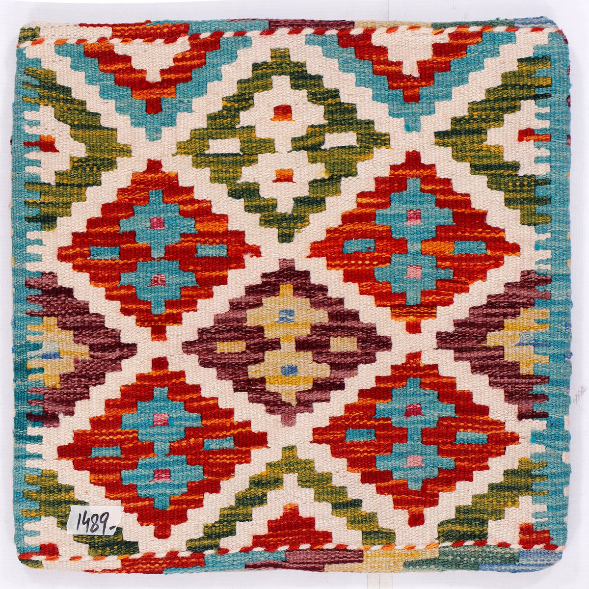 Kilim cushion cover front with tight diamond pattern in red, teal, green, and cream