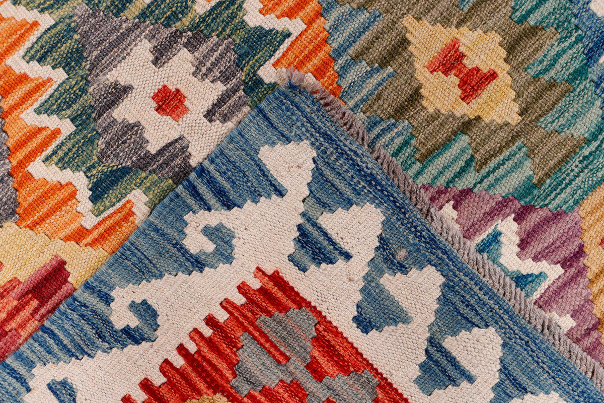 Close-up of kilim rug weave with blue diamond shapes and red accents