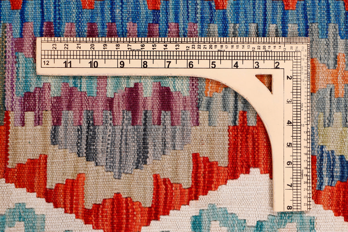Kilim rug texture close-up with geometric motifs and ruler for size detail