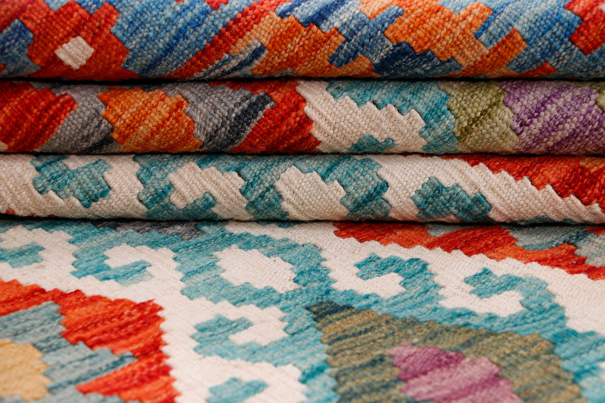 Kilim rug edge close-up showing layered pile and orange, blue, and cream motifs