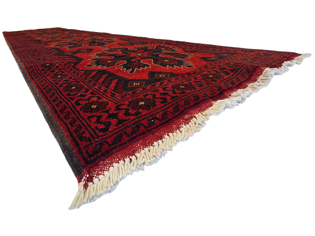 Maroon 290x79 rug with repeating geometric motifs and cream fringe along the edges