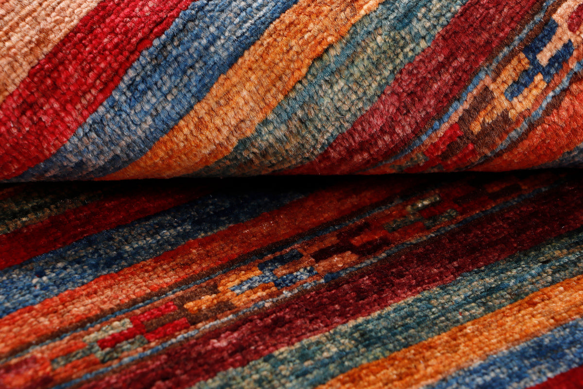 Red wool rug with multicolor striped woven pattern, close-up texture