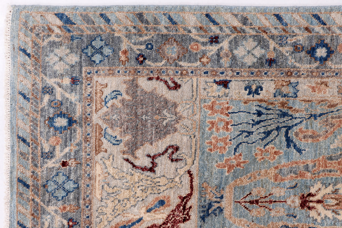 Khyber Oushak rug panel detail, light blue background with beige and red motifs