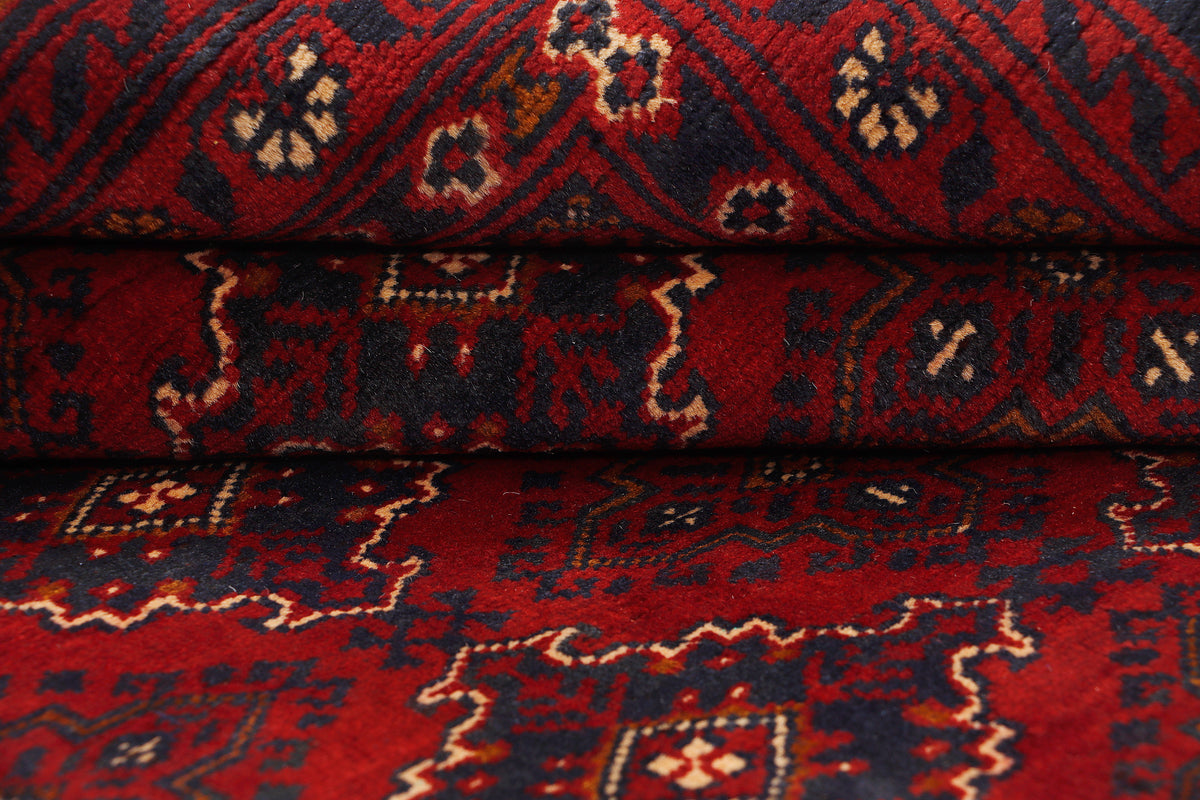 Folded red rug showing woven texture and small diamond pattern accents