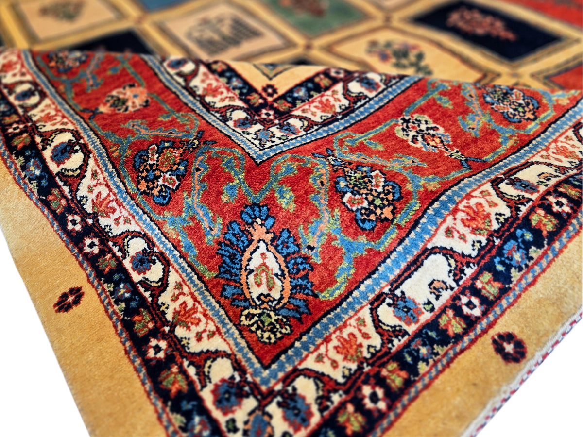 Rug corner detail with teal, red, and cream shapes plus dark blue ornamental border