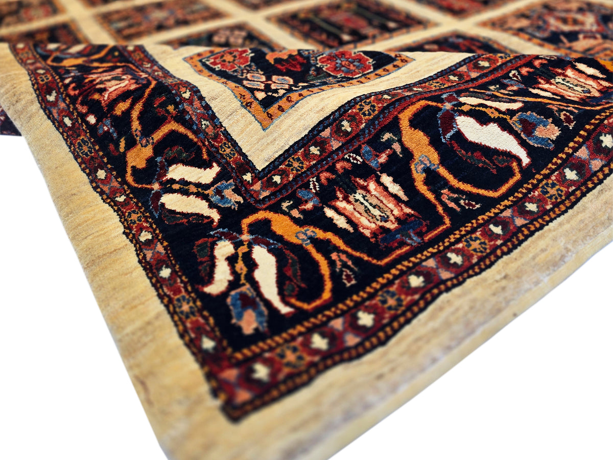 Loribaft rug corner detail with navy motifs, rust accents, and cream ground