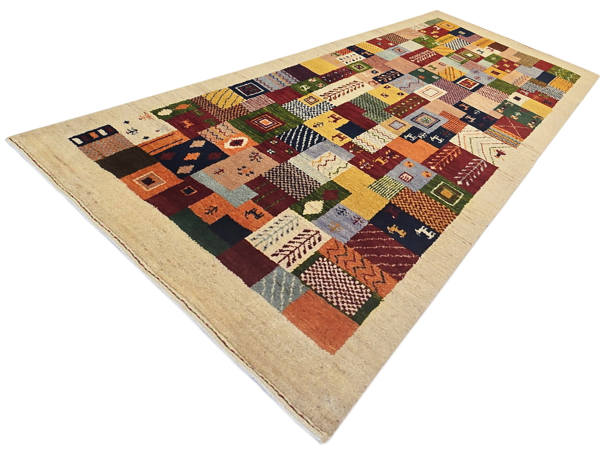 Patchwork Loribaft rug with multicolor geometric squares on a beige background.
