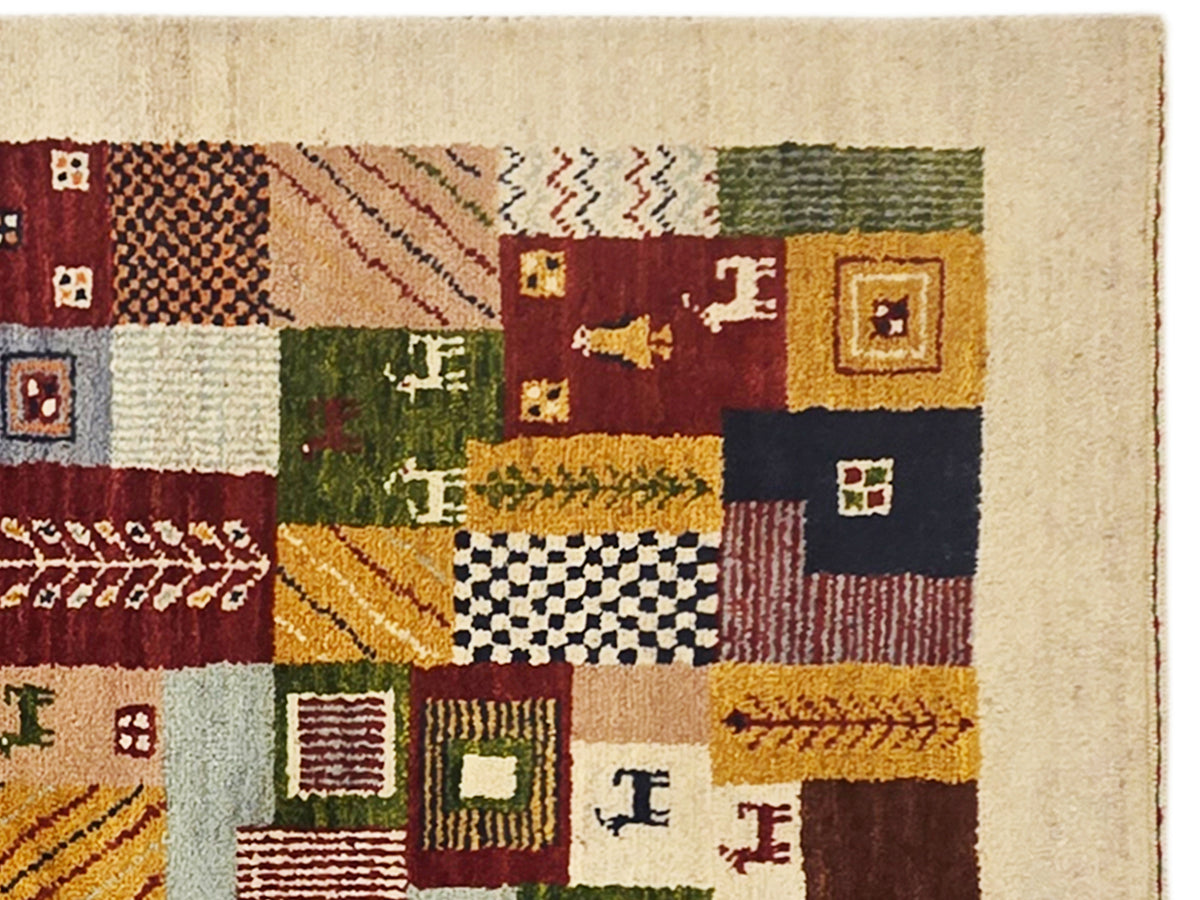 Close-up of Loribaft rug showing textured patches in red, navy, green, and cream.