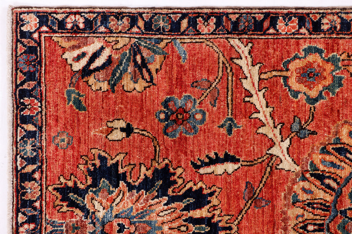 Red patterned rug with dense floral and ornamental motifs in blue and cream