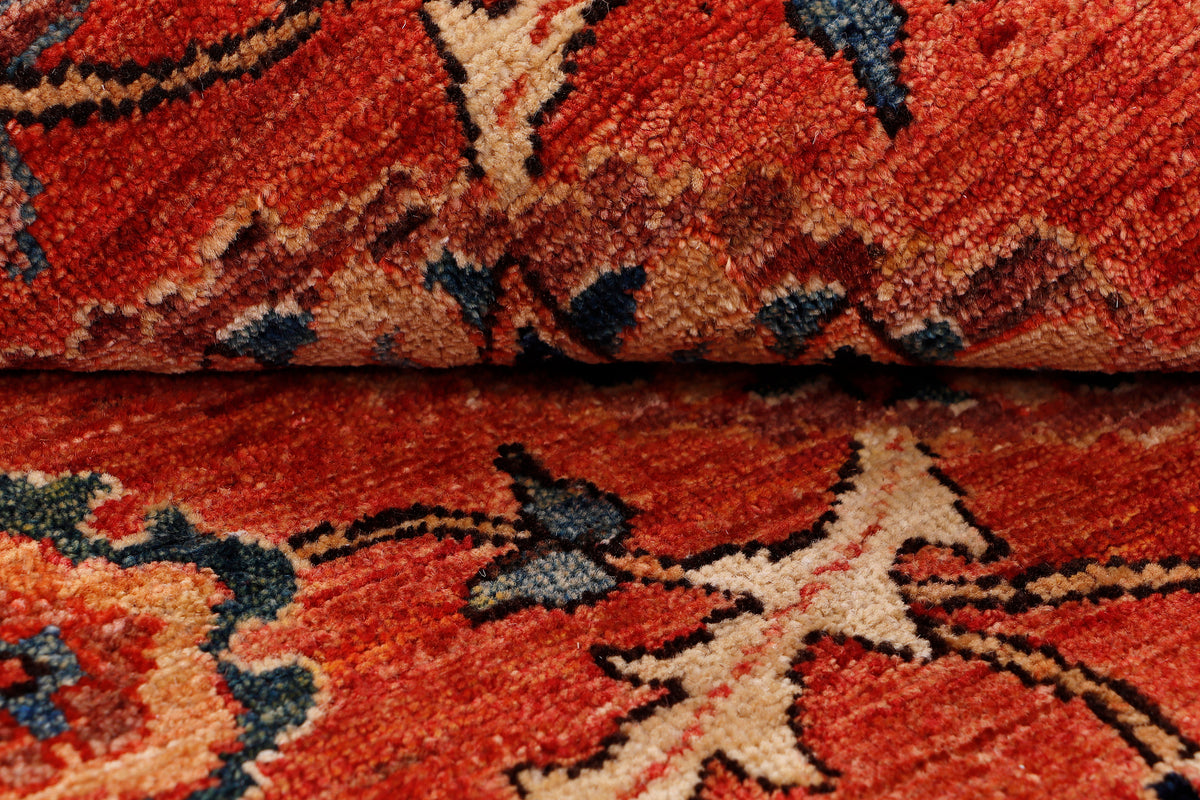 Red patterned rug close-up with floral motifs and blue accents