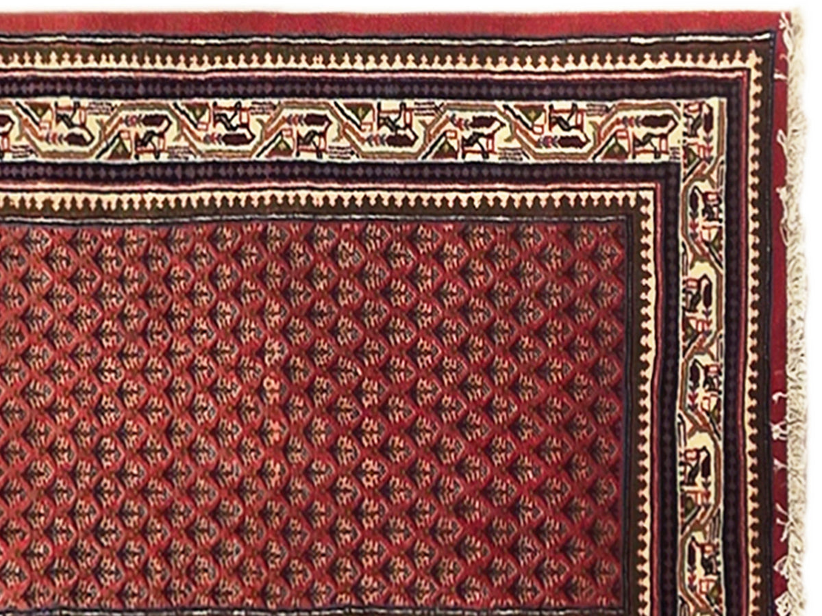 Close-up of red rug panel with black border, gold trim, and geometric motifs