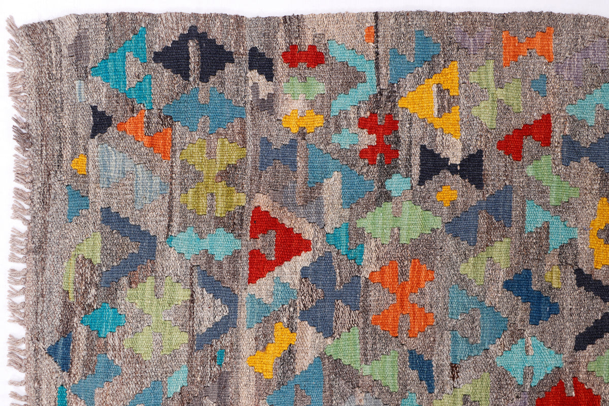 Kelim rug corner with multicolor star motifs and short fringes along the edge