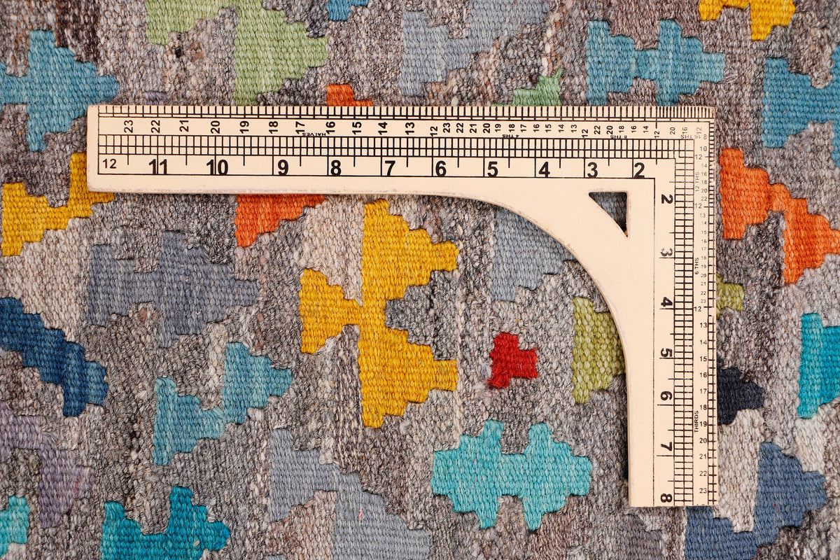 Kelim rug pattern with multicolor cross motifs; ruler shows pile height and weave detail