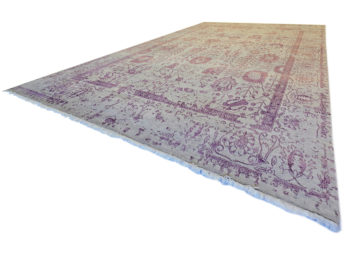 Modern beige area rug with purple ornate pattern and short fringed edges