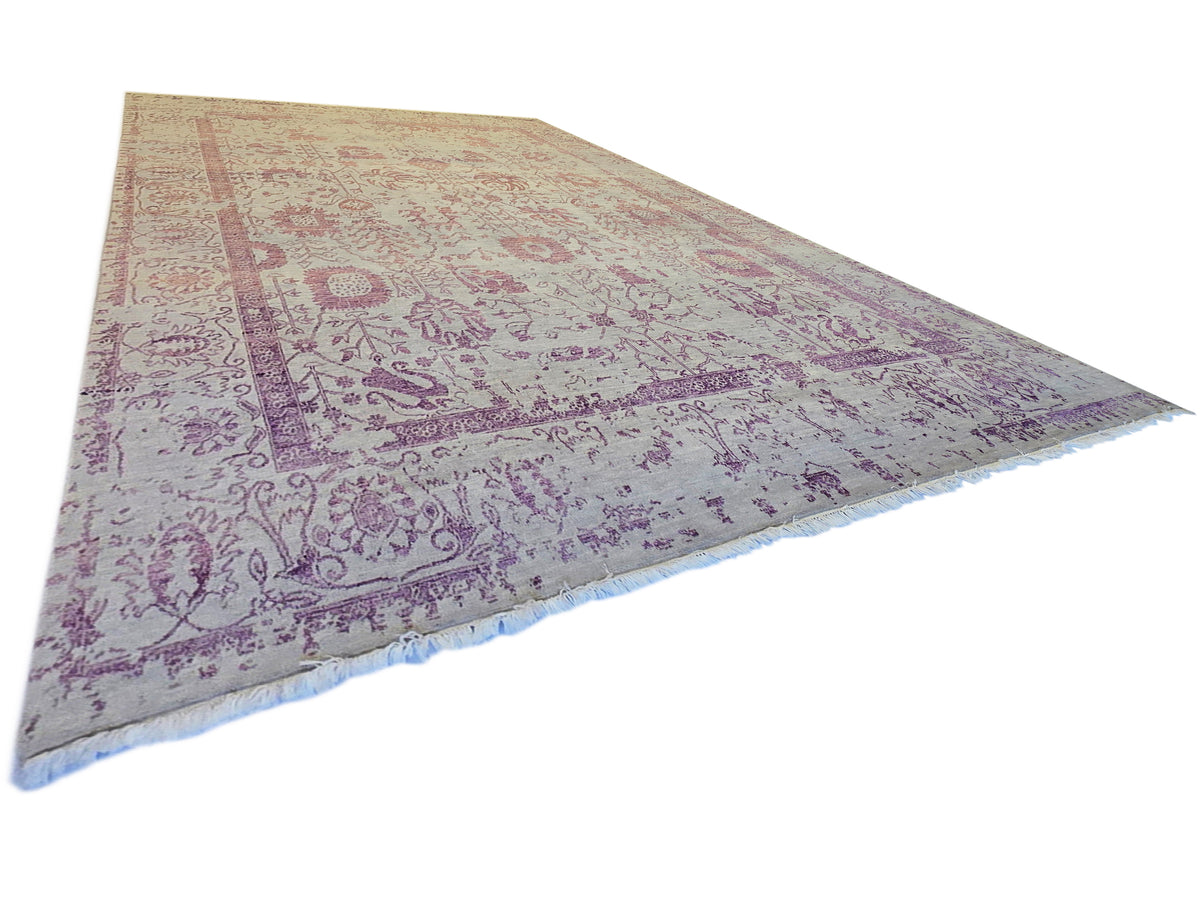 Modern beige area rug with purple border pattern and fringed edge