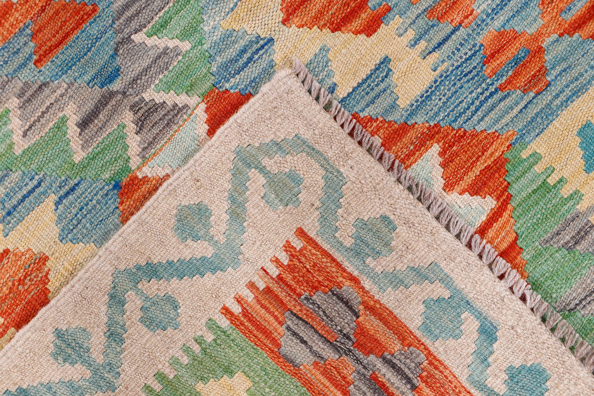 Flatweave rug corner with medallion motif in orange, blue, green, and fringe detail