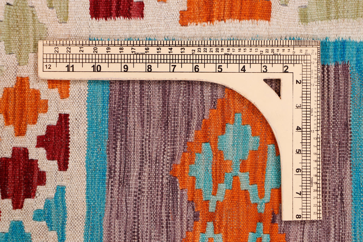 Multicolor kilim rug section with measuring tape and ruler across the weave