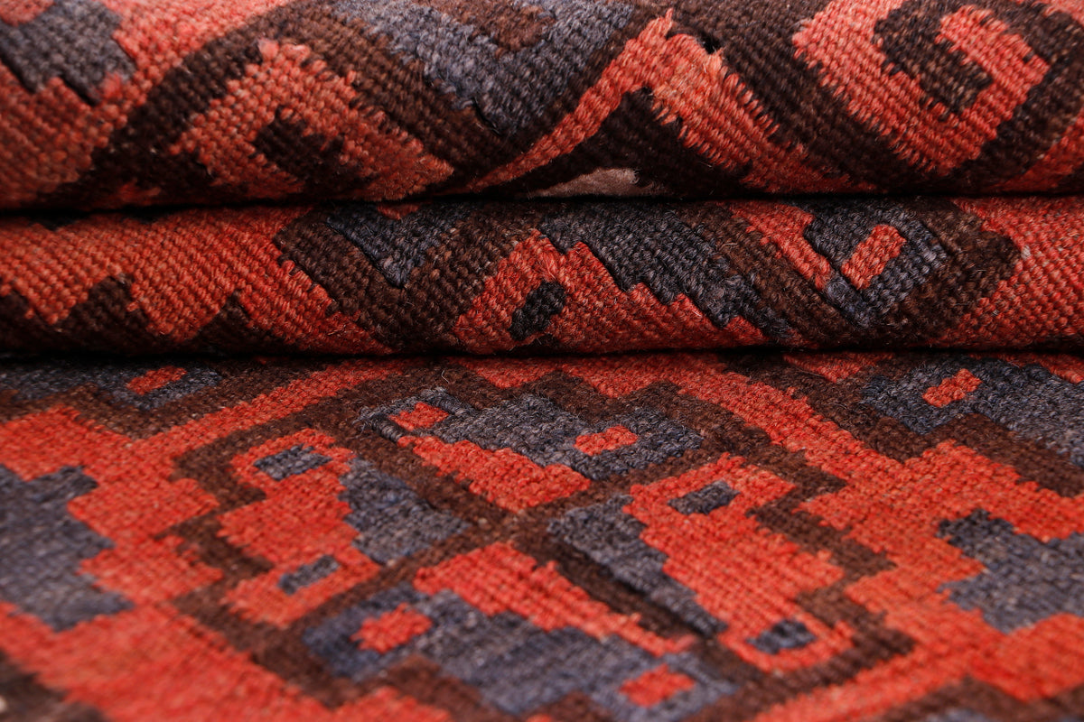Woven kilim rug texture in red and dark blue with repeating pattern