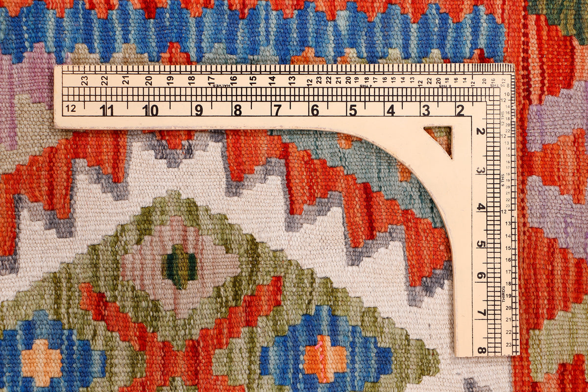 Kilim rug close-up showing multicolor geometric motifs and inch ruler measuring detail
