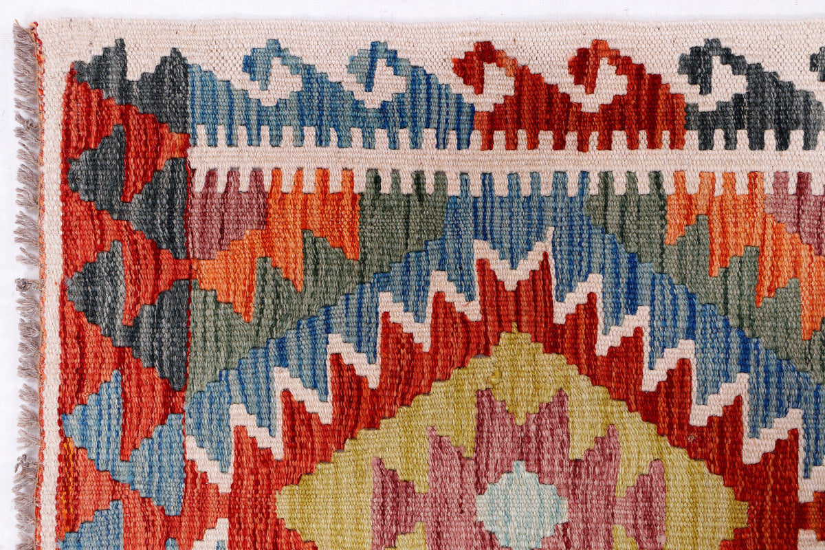Kilim rug border close-up with zigzag rows in red, blue, gray, and cream