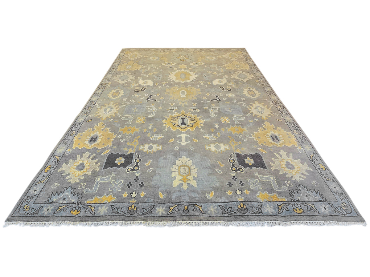 Oushak rug with gray base and yellow medallion floral motifs, wide border.