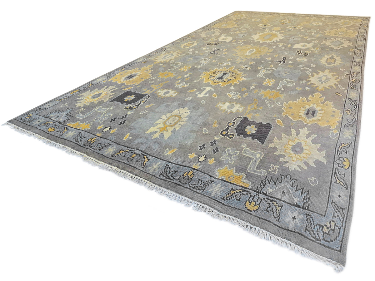 Oushak rug with gray and yellow patterning, angled view; subtle fringed edge.