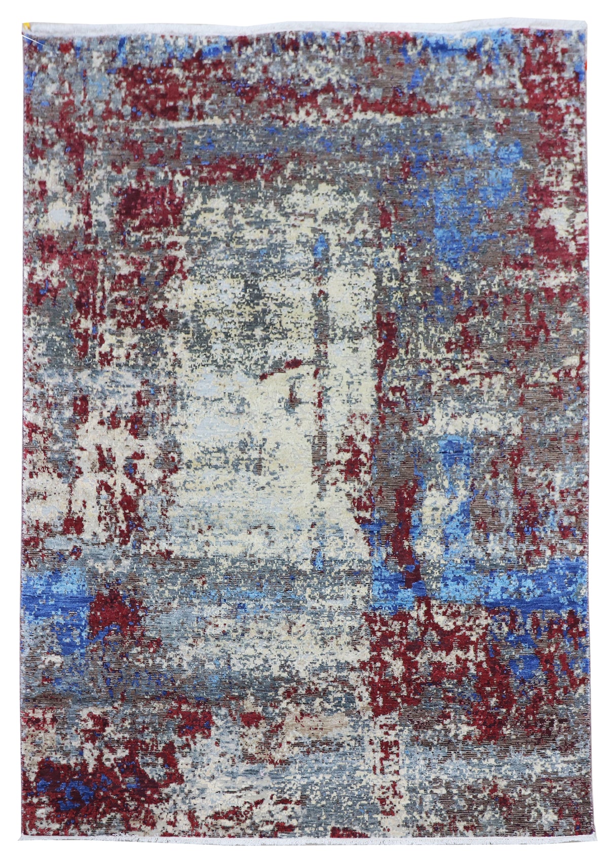 Rectangular abstract rug with off-white base and blue and crimson distressed design