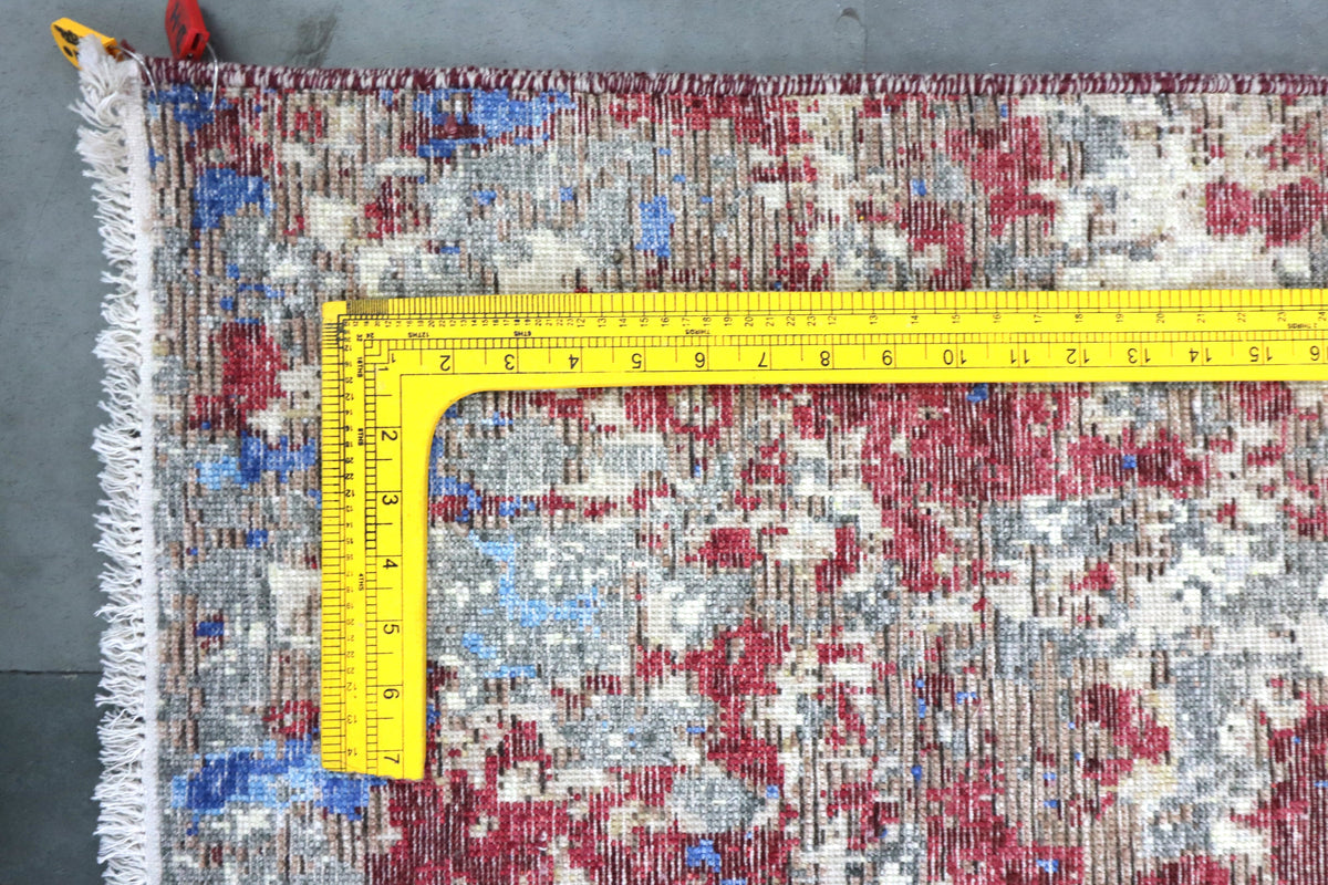 Abstract rug close-up with distressed blue, red, and white pattern and frayed edge